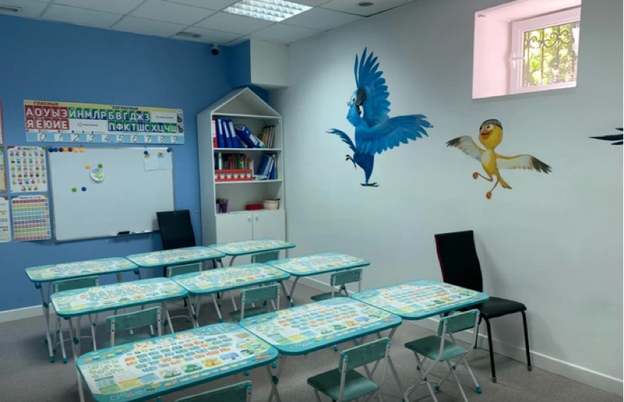 Учебный класс с партами и яркими птицами на стене
